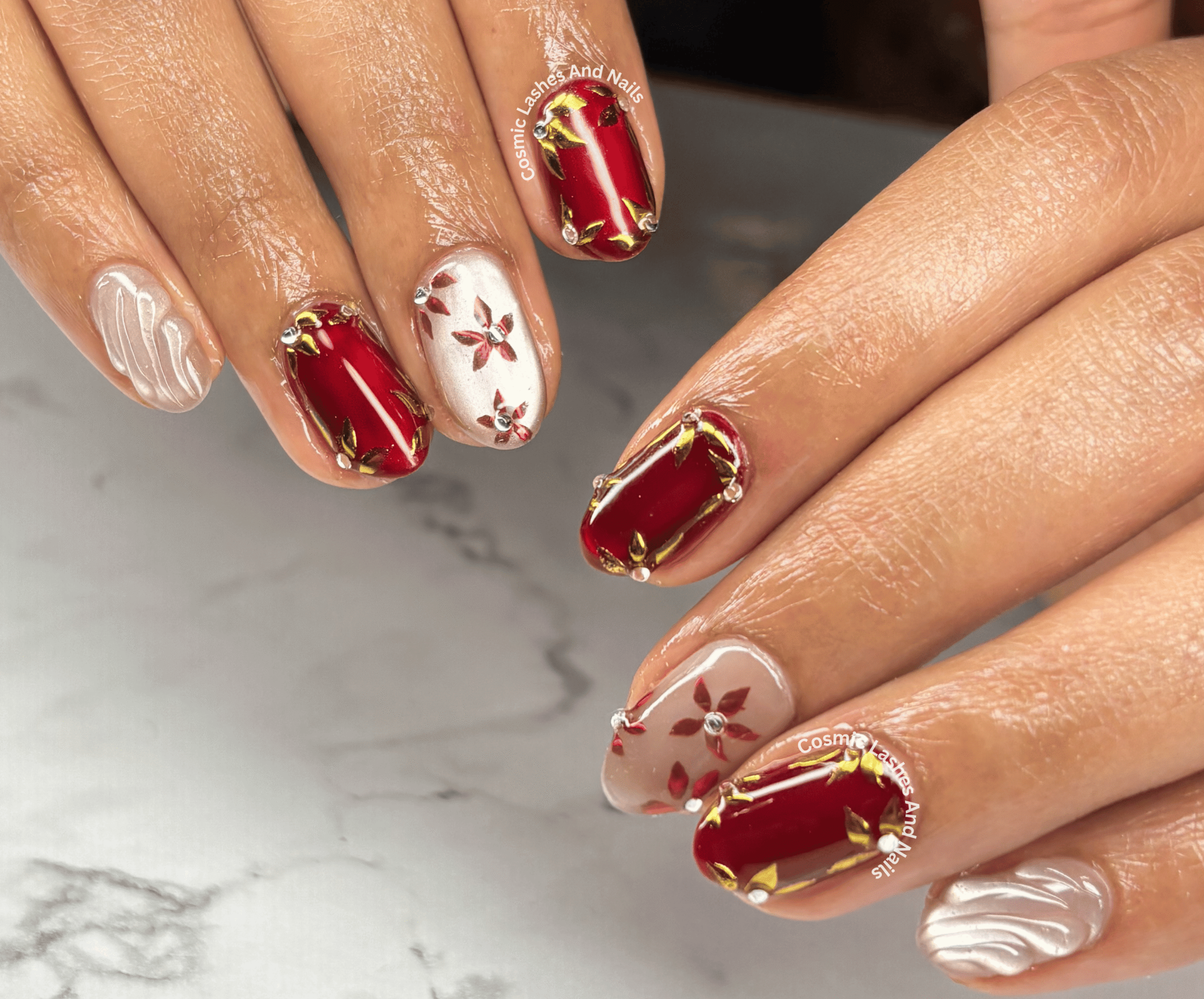 Red and gold nail art design with 3D floral details